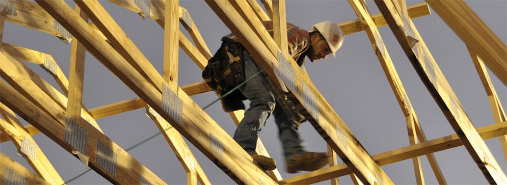 a person with a hard hat standing on wooden beams